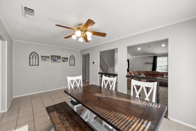 tiled dining room with ornamental molding and ceiling fan