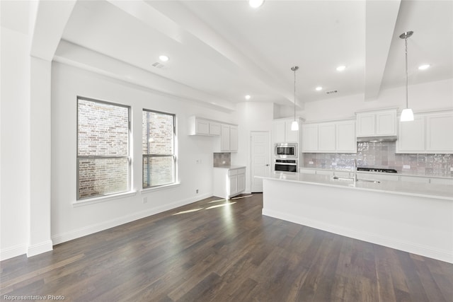 kitchen featuring tasteful backsplash, hanging light fixtures, and white cabinets