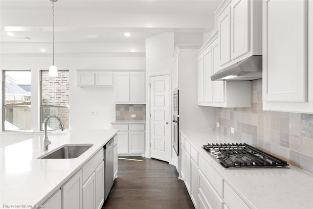 kitchen with sink, white cabinetry, decorative light fixtures, appliances with stainless steel finishes, and light stone countertops