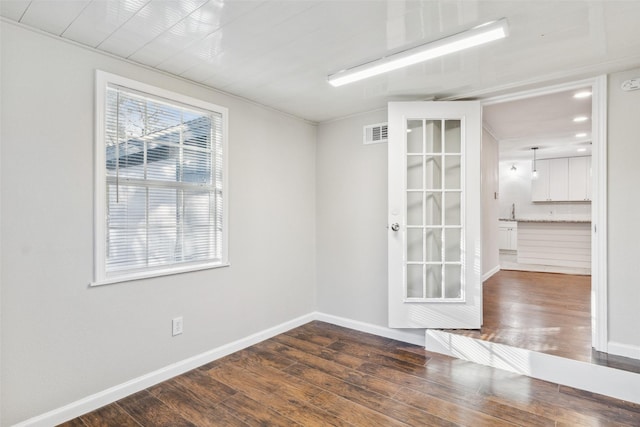 empty room with dark hardwood / wood-style flooring and sink