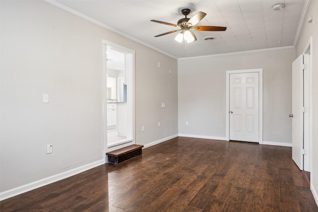 empty room with ceiling fan, crown molding, and dark wood-type flooring