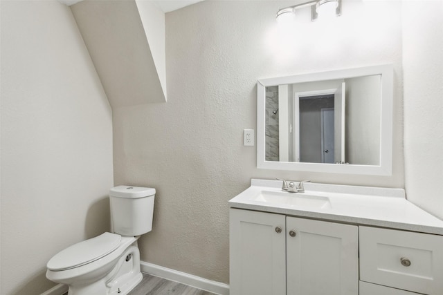 bathroom featuring wood-type flooring, vanity, and toilet