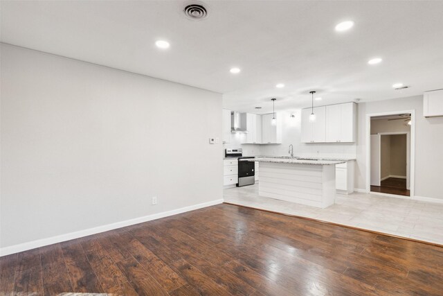 unfurnished living room featuring sink and light hardwood / wood-style floors