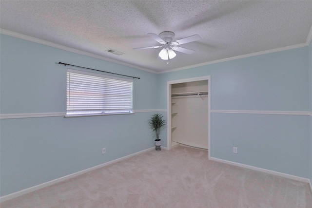 unfurnished bedroom with a textured ceiling, a closet, light colored carpet, and ceiling fan