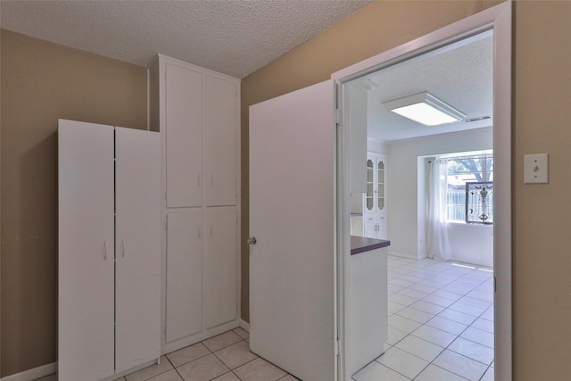 hall with light tile patterned floors and a textured ceiling