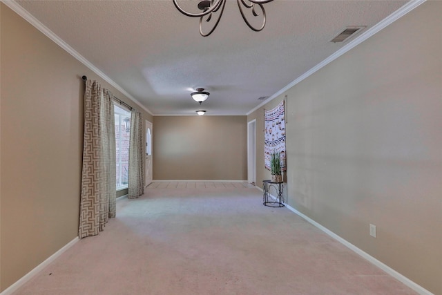 carpeted spare room featuring crown molding and a textured ceiling