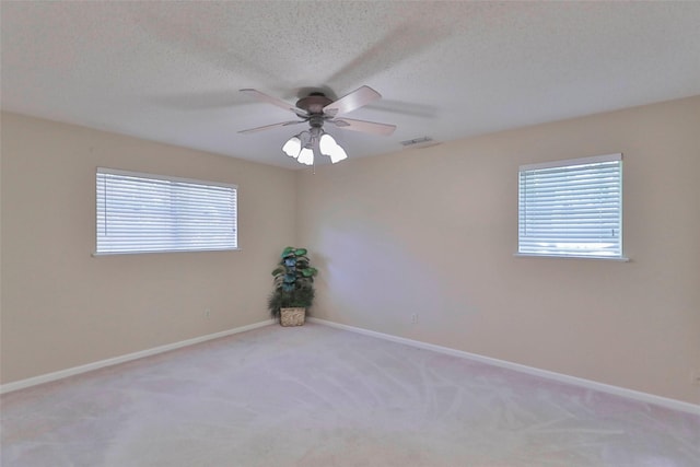 carpeted spare room with ceiling fan and a textured ceiling