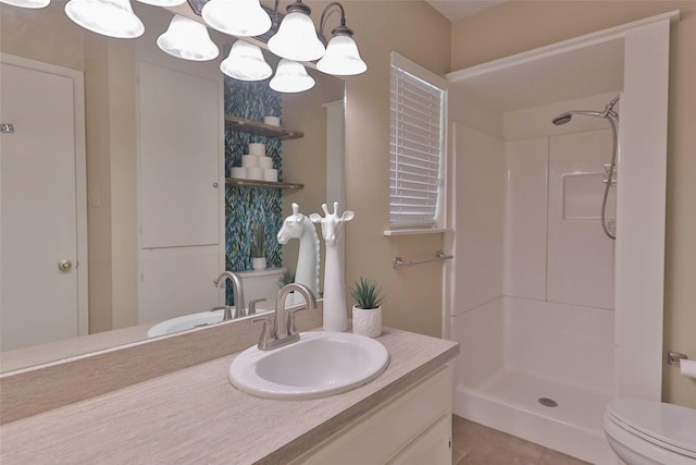 bathroom featuring a notable chandelier, tile patterned floors, a shower, toilet, and vanity