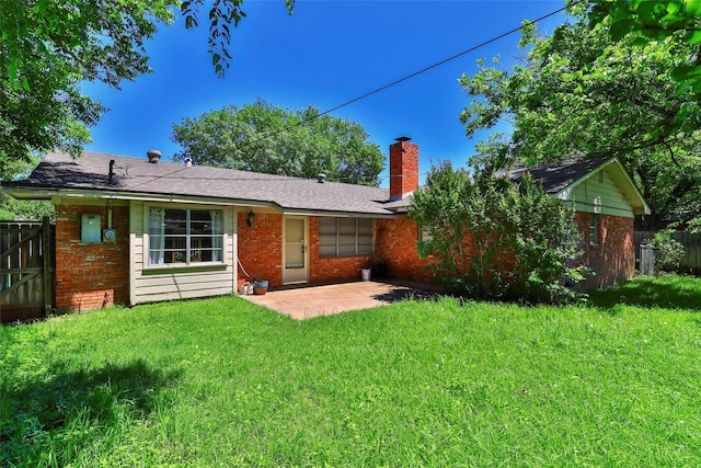 rear view of property with a patio and a lawn