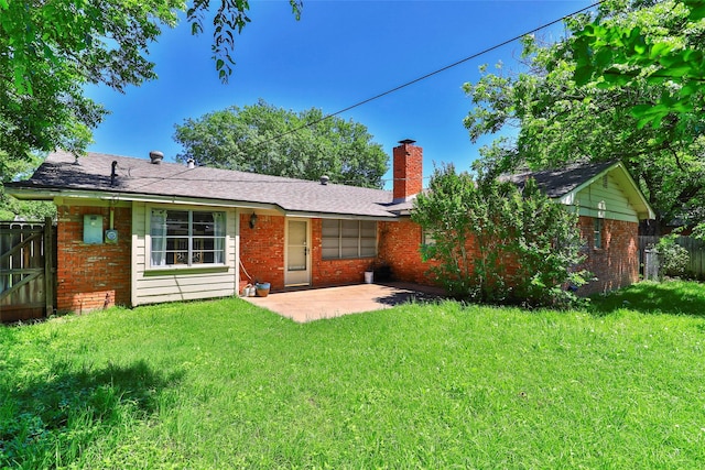 back of house with a lawn and a patio area