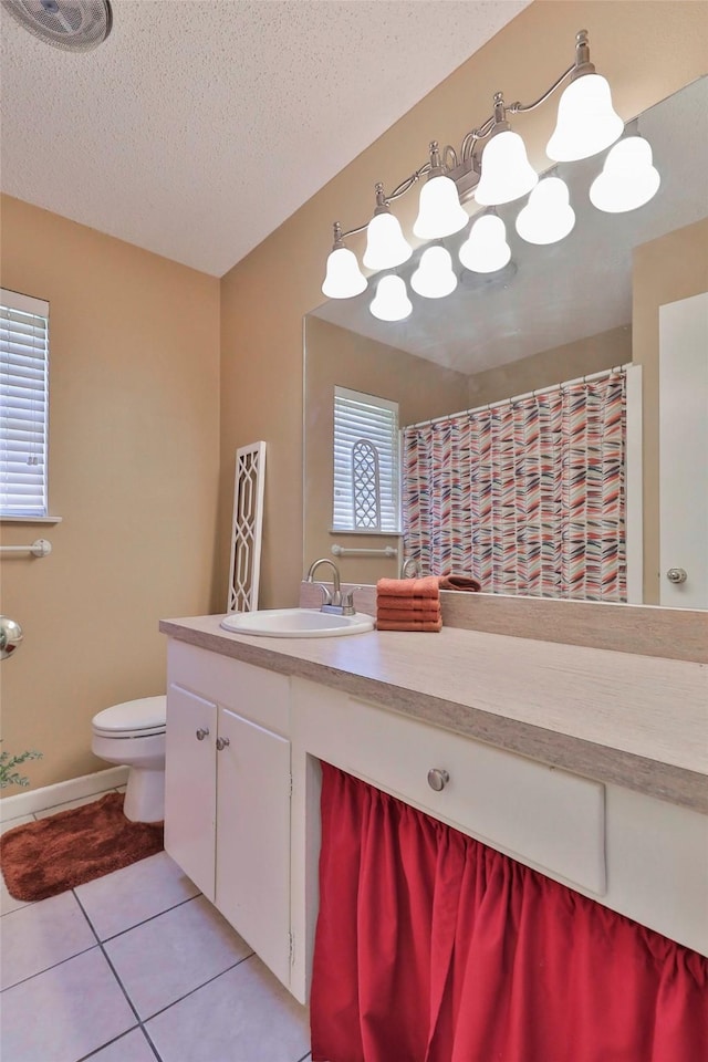 bathroom with tile patterned flooring, vanity, toilet, and a textured ceiling