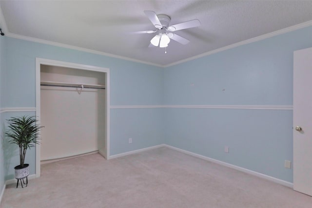 unfurnished bedroom with ceiling fan, a closet, light colored carpet, and ornamental molding