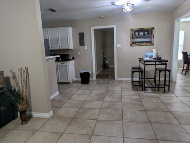 interior space with light tile patterned floors and white cabinetry