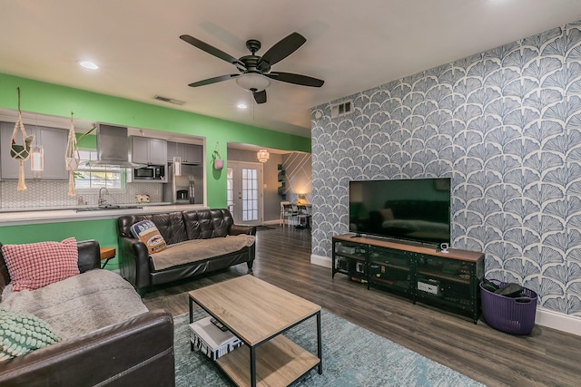 living room featuring ceiling fan, dark hardwood / wood-style flooring, sink, and french doors