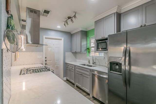 kitchen featuring gray cabinetry, sink, stainless steel appliances, and exhaust hood