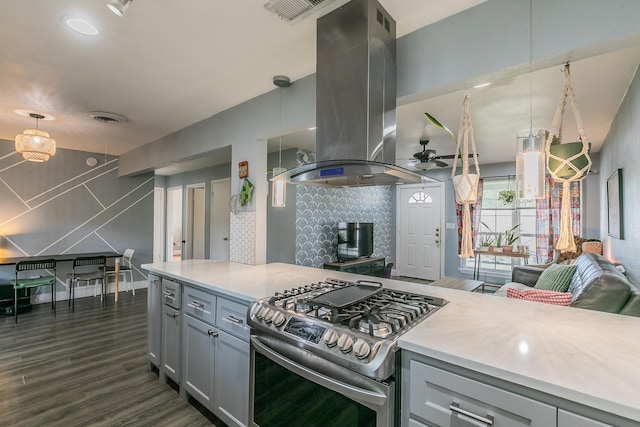 kitchen with dark hardwood / wood-style flooring, gas stove, island range hood, ceiling fan, and pendant lighting