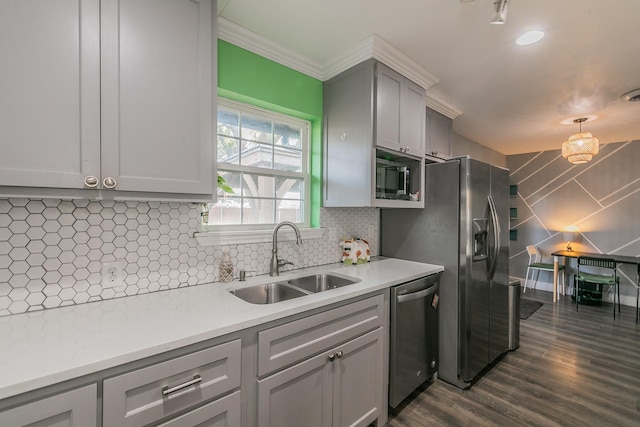 kitchen with sink, decorative backsplash, ornamental molding, appliances with stainless steel finishes, and dark hardwood / wood-style flooring