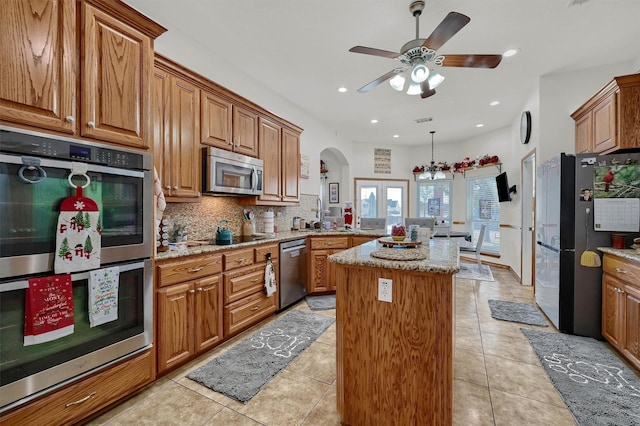 kitchen with french doors, a kitchen island, black appliances, and light tile patterned floors