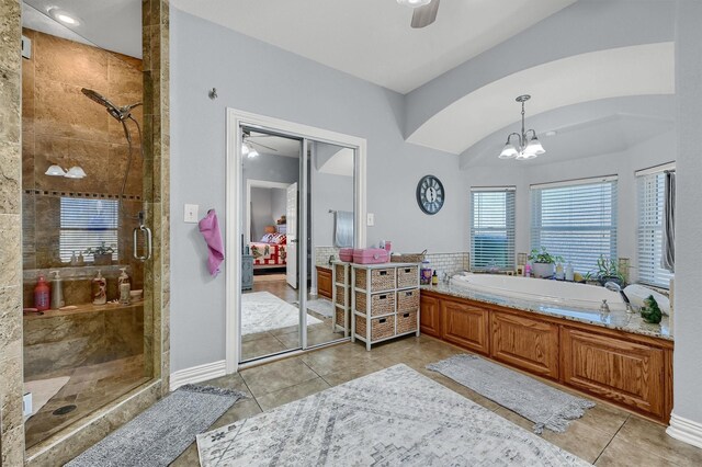 bathroom featuring tile patterned flooring, plus walk in shower, and a notable chandelier