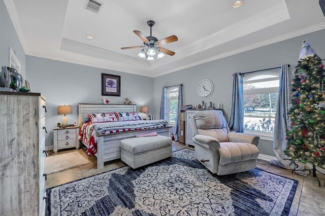 tiled bedroom with a raised ceiling, multiple windows, and ceiling fan