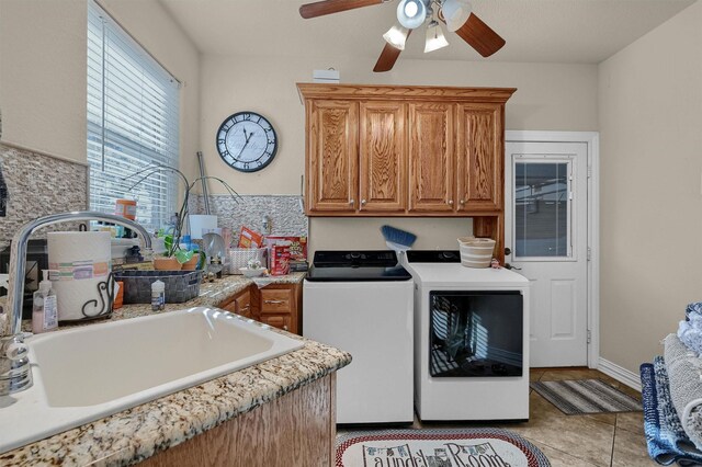 clothes washing area with cabinets, sink, ceiling fan, separate washer and dryer, and light tile patterned floors