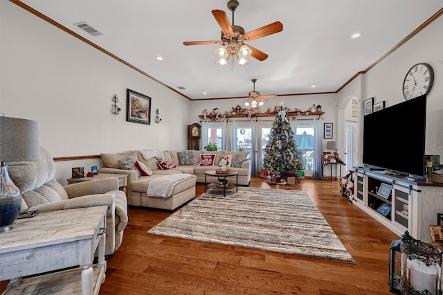 living room with hardwood / wood-style flooring, ceiling fan, and ornamental molding