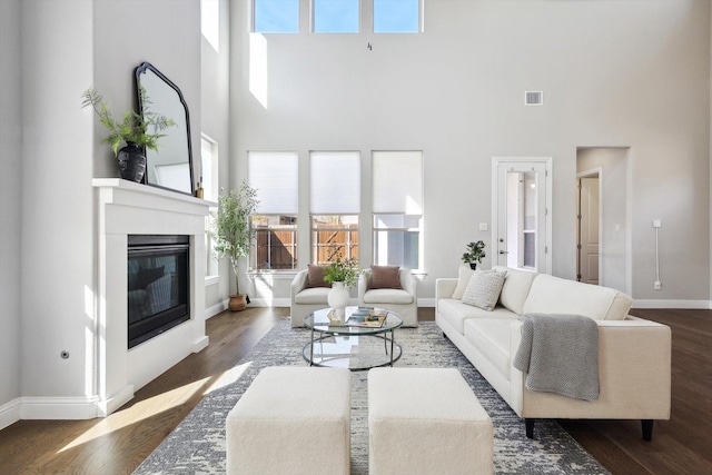 living room featuring dark hardwood / wood-style flooring and a high ceiling