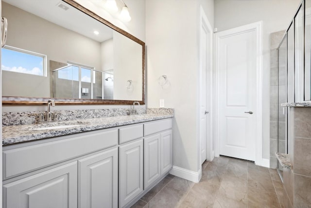 727 Waterbrook Pkwy, Argyle, TX 76226 - bathroom with double vanity, visible vents, a stall shower, a sink, and baseboards