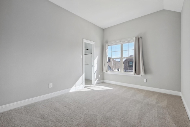 empty room with light carpet and lofted ceiling