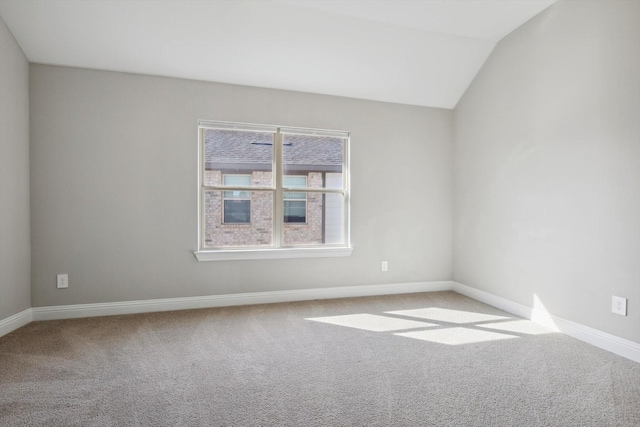 empty room with light colored carpet and lofted ceiling