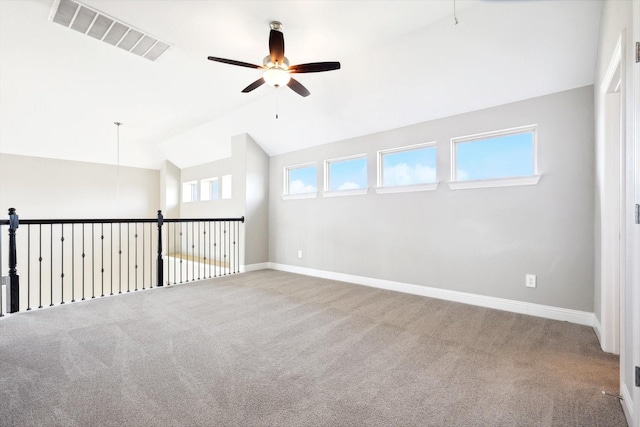 carpeted spare room featuring vaulted ceiling and ceiling fan