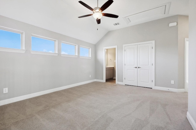 unfurnished bedroom with ensuite bath, ceiling fan, light carpet, and vaulted ceiling