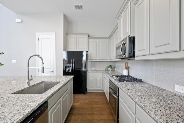 kitchen with tasteful backsplash, visible vents, appliances with stainless steel finishes, dark wood-style flooring, and a sink