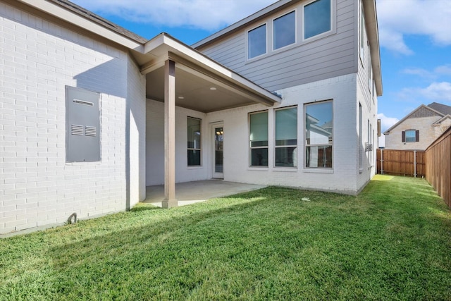 rear view of house with a yard and a patio