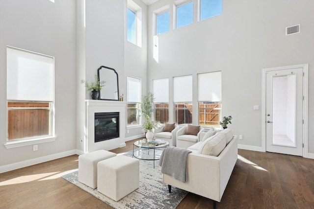 living room featuring dark hardwood / wood-style floors and a high ceiling