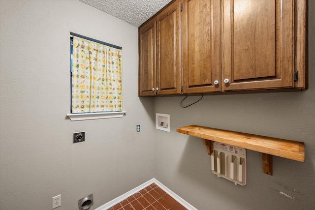 clothes washing area with cabinets, washer hookup, a textured ceiling, electric dryer hookup, and dark tile patterned flooring