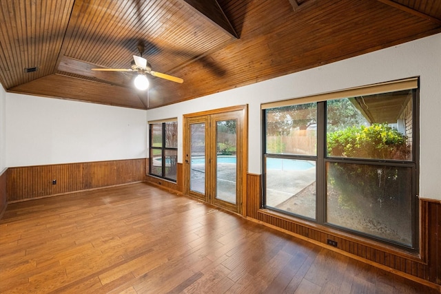 unfurnished room with ceiling fan, a healthy amount of sunlight, hardwood / wood-style floors, and wood ceiling