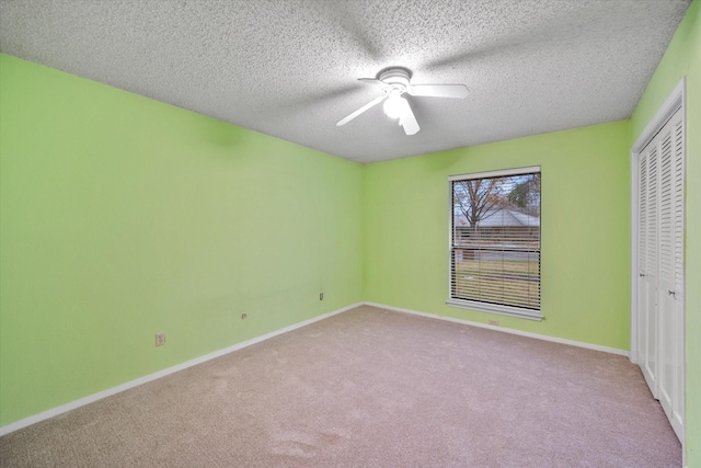 unfurnished bedroom with light carpet, a textured ceiling, ceiling fan, and a closet