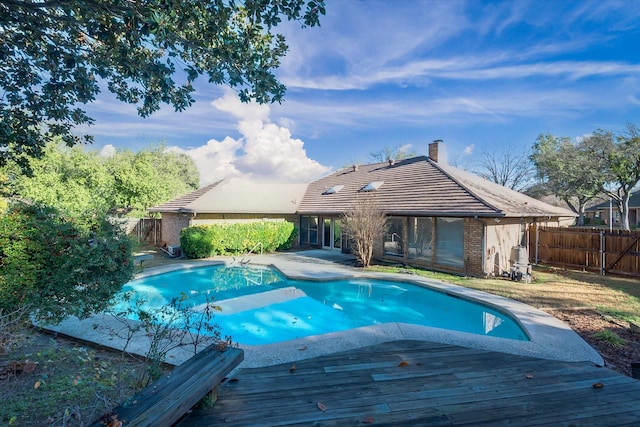 view of pool with a diving board and a deck