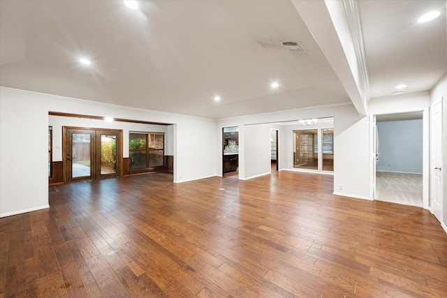 unfurnished living room with wood-type flooring, crown molding, and french doors