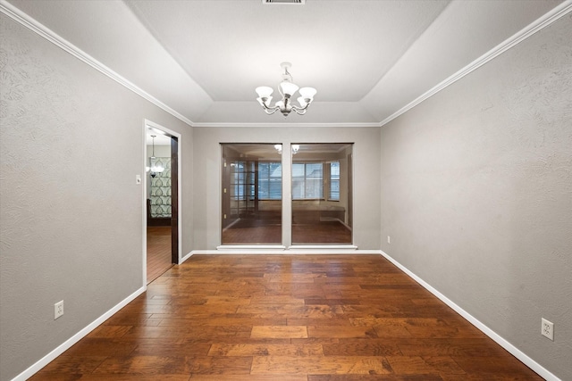 unfurnished dining area featuring a raised ceiling, dark hardwood / wood-style flooring, ornamental molding, and a chandelier