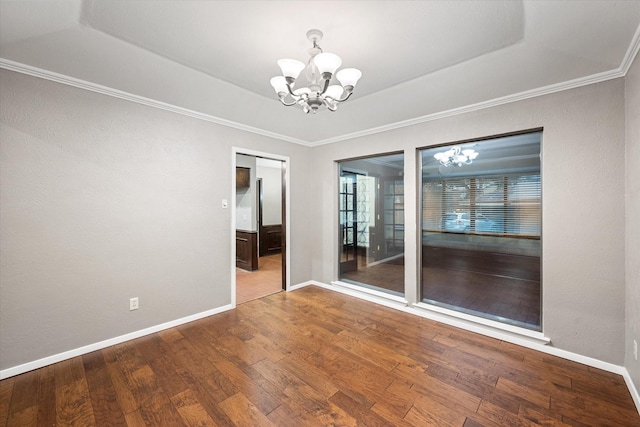 spare room featuring hardwood / wood-style flooring, a raised ceiling, and a chandelier