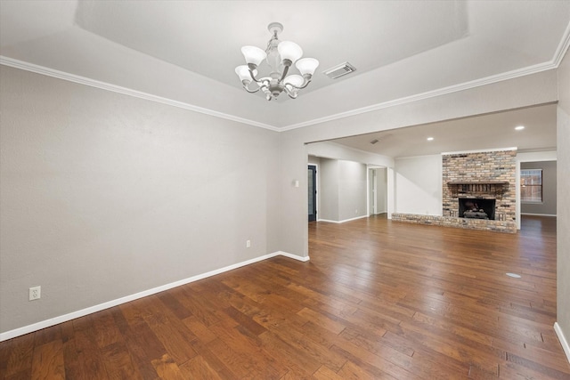 unfurnished living room with dark hardwood / wood-style flooring, crown molding, a raised ceiling, and an inviting chandelier