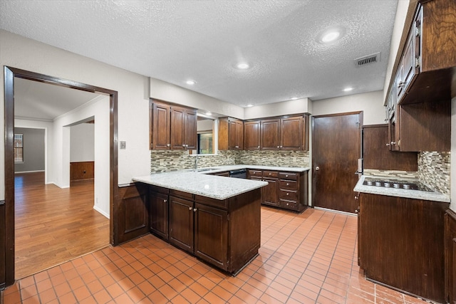 kitchen with black electric cooktop, dark brown cabinetry, backsplash, and light tile patterned floors