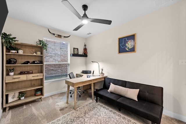 carpeted home office featuring ceiling fan