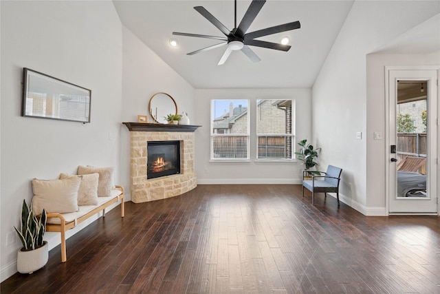 living area with dark wood-style flooring, a fireplace, plenty of natural light, and baseboards