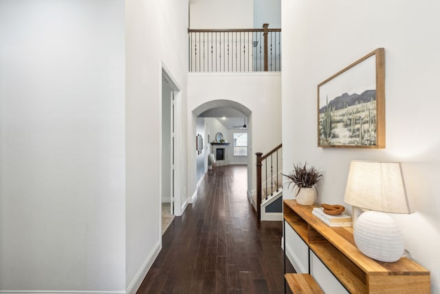 corridor featuring a high ceiling and dark hardwood / wood-style flooring