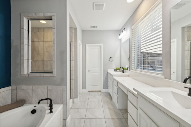 bathroom featuring tile patterned floors, vanity, and shower with separate bathtub