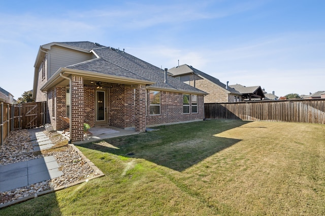 rear view of property featuring a yard and a patio