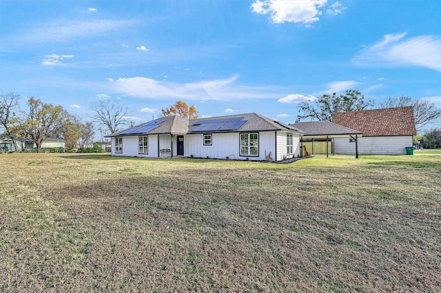 view of front of house with a carport, a front yard, and solar panels